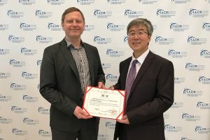 Professor Liangjia Bi (R) from the Department of Stomatology, Fourth Affiliated Hospital, Harbin Medical University, China, presents an honorary professorship to Dr. Hannu Larjava.